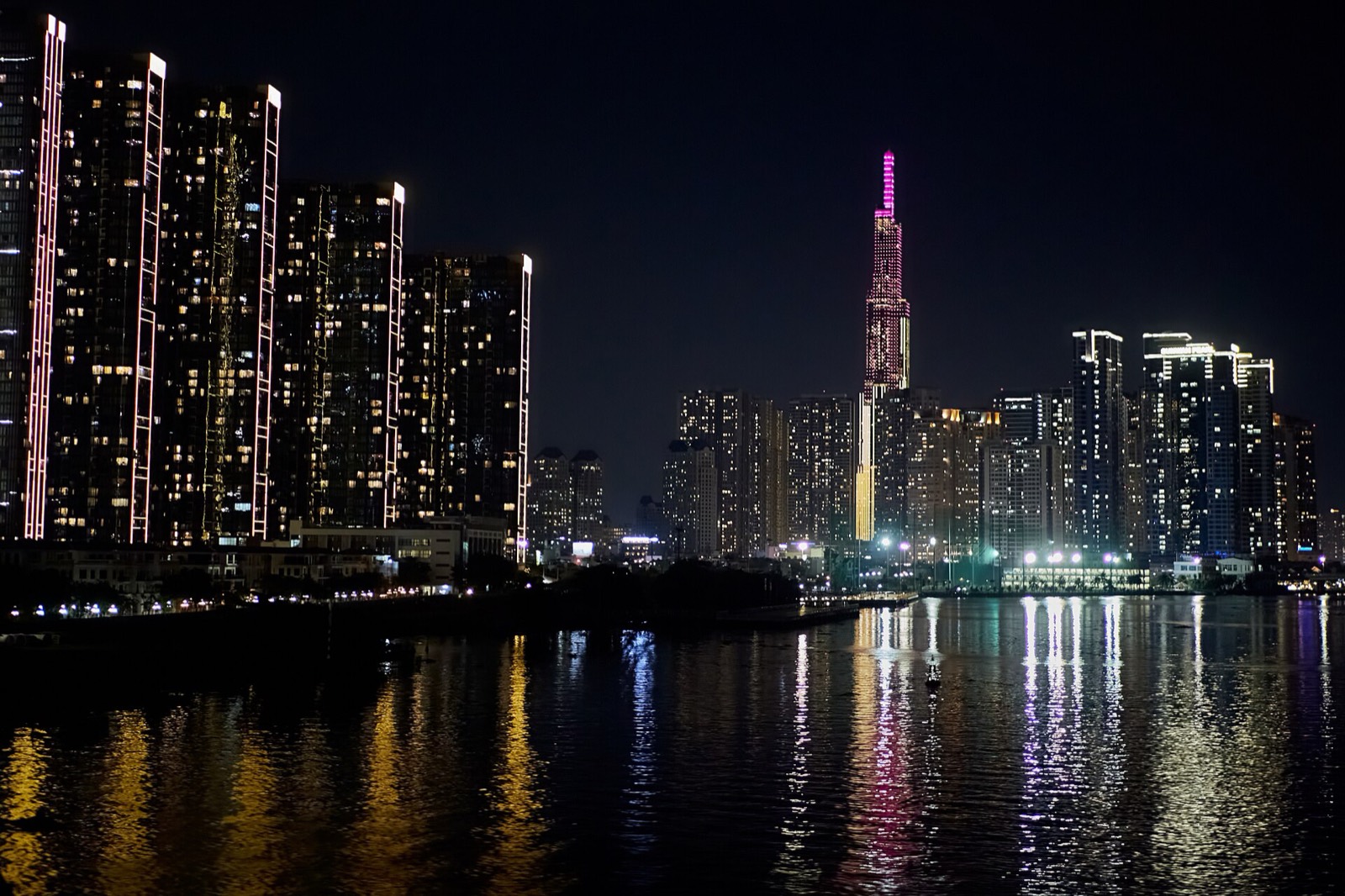 Ho Chi Minh City at night, towers lit across the Saigon River